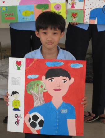 Vietnamese boy holding self portrait with soccer ball. Anh Linh School Vietnam.