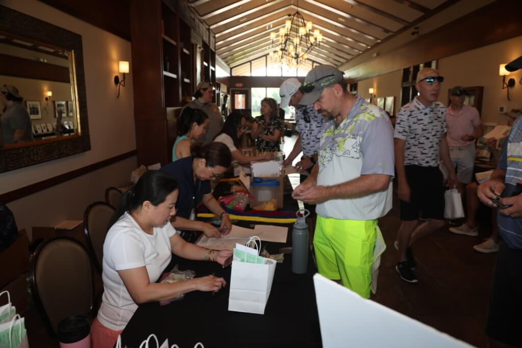 Volunteers help golfers check in at the 4th Annual Bridges to Learning Golf Tournament at The Wilds Golf Club, Prior Lake Minnesota. Raising funds to educate and care for poor children in Vietnam.