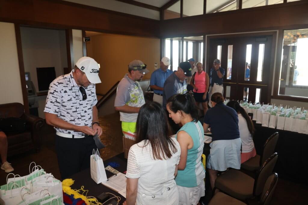 Volunteers help golfers check in at the 4th Annual Bridges to Learning Golf Tournament at The Wilds Golf Club, Prior Lake Minnesota. Raising funds to educate and care for poor children in Vietnam.