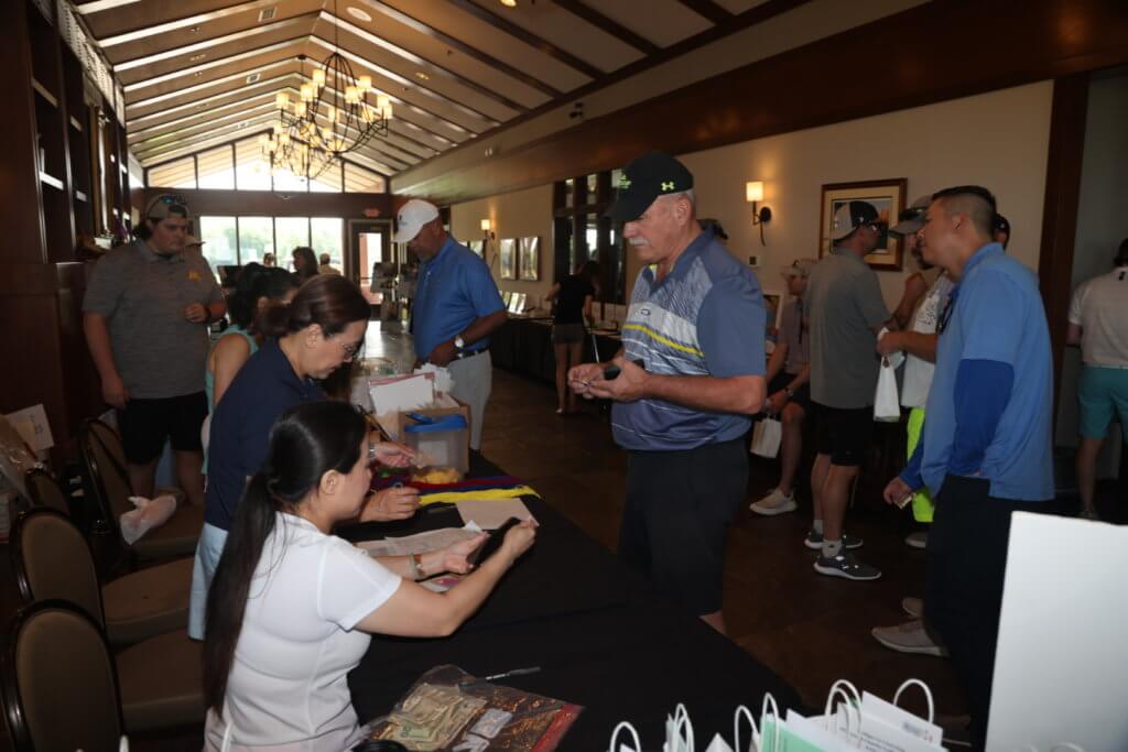 Volunteers help golfers check in at the  4th Annual Bridges to Learning Golf Tournament at The Wilds Golf Club, Prior Lake Minnesota. Raising funds to educate and care for poor children in Vietnam.