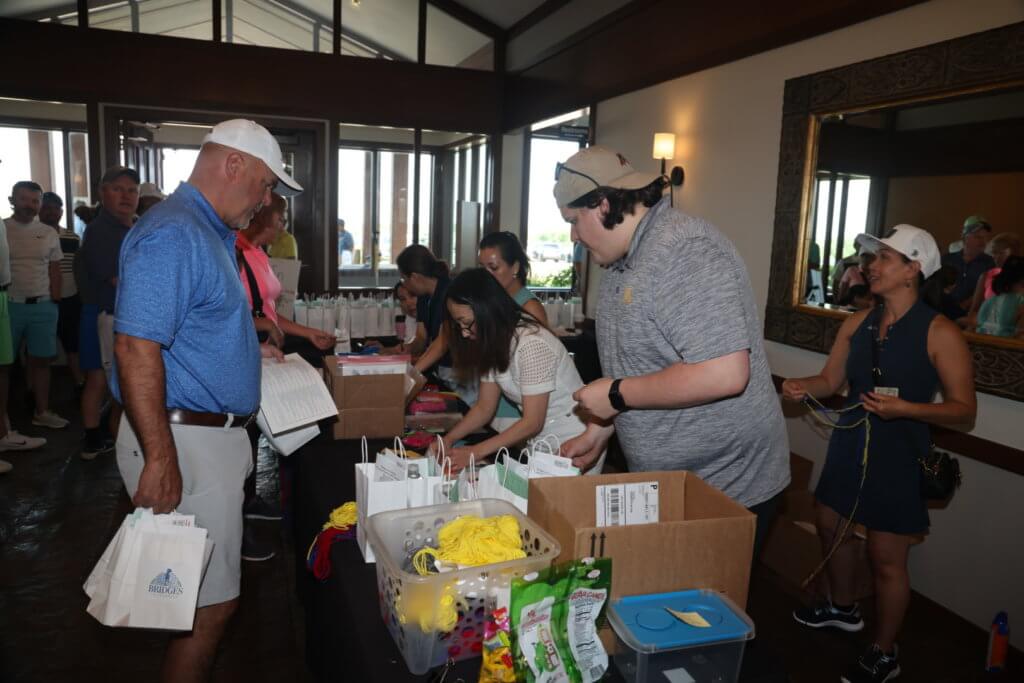 Volunteers help golfer check in at the 4th Annual Bridges to Learning Golf Tournament at The Wilds Golf Club, Prior Lake Minnesota. Raising funds to educate and care for poor children in Vietnam.