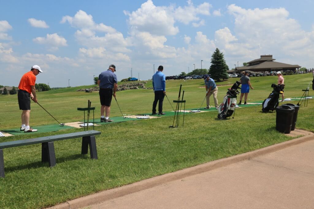 Golfers warming up at the driving range at the 4th Annual Bridges to Learning Golf Tournament at The Wilds Golf Club, Prior Lake Minnesota. Raising funds to educate and care for poor children in Vietnam.