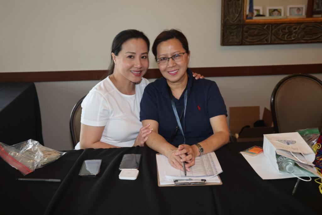 Two volunteers pose for a photo at check in at the 4th Annual Bridges to Learning Golf Tournament at The Wilds Golf Club, Prior Lake Minnesota. Raising funds to educate and care for poor children in Vietnam.