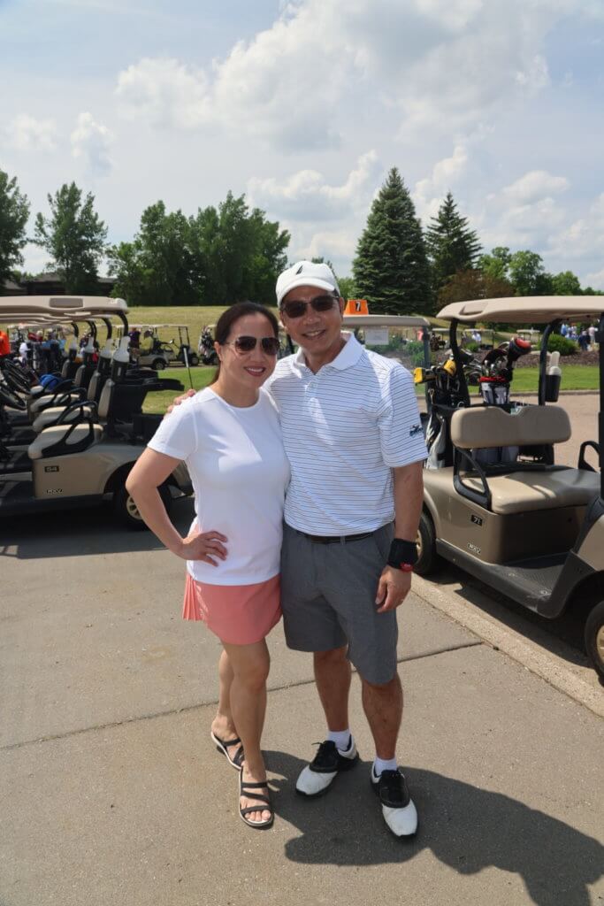Couple pose for a photo at the 4th Annual Bridges to Learning Golf Tournament at The Wilds Golf Club, Prior Lake Minnesota. Raising funds to educate and care for poor children in Vietnam.