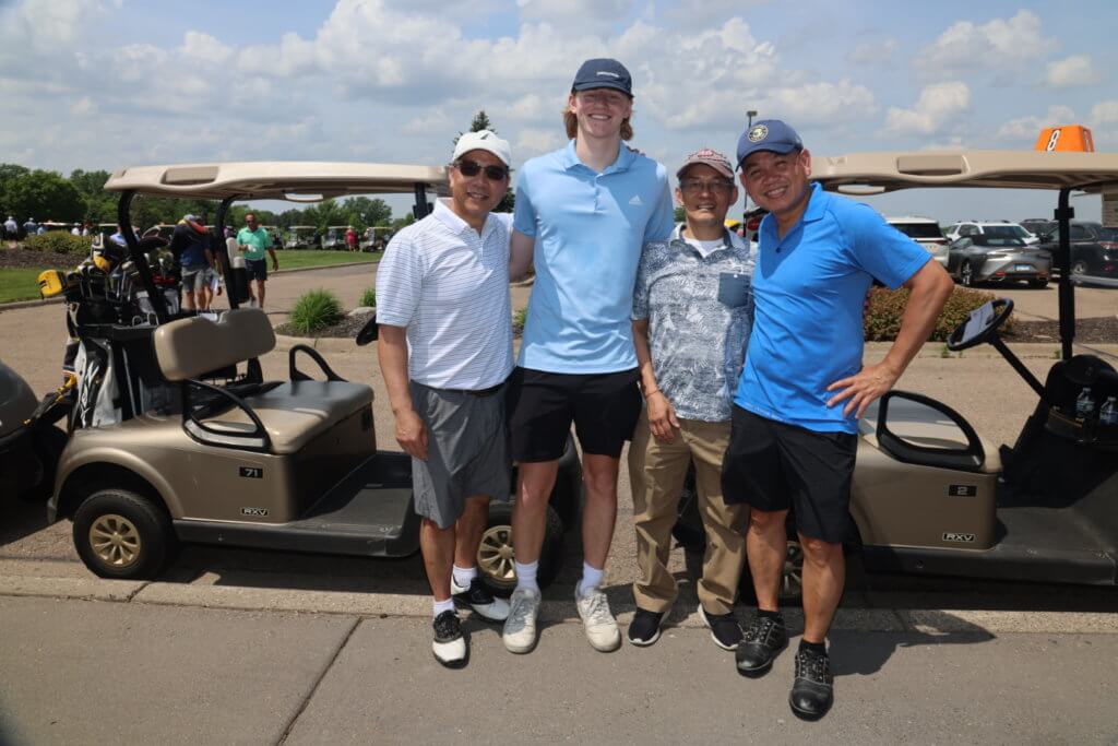 Golfers pose for a picture by their golf cart before heading out to play at the 4th Annual Bridges to Learning Golf Tournament at The Wilds Golf Club, Prior Lake Minnesota. Raising funds to educate and care for poor children in Vietnam.