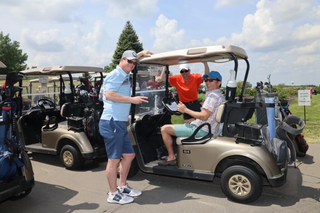 Golfers pose for a picture at their golf cart before heading out to play at the 4th Annual Bridges to Learning Golf Tournament at The Wilds Golf Club, Prior Lake Minnesota. Raising funds to educate and care for poor children in Vietnam.