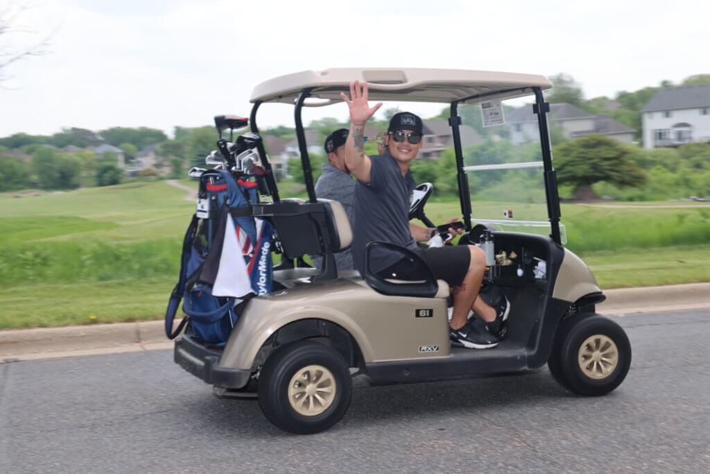 Golfer waves as he heads out to play at the Wilds Golf Club course at the 4th Annual Bridges to Learning Golf Tournament, Prior Lake Minnesota. Raising funds to educate and care for poor children in Vietnam.
