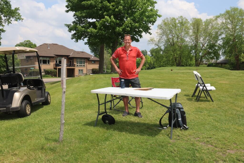 Volunteer waits at a table for the golfers to arrive at the Wilds Golf Club course at the 4th Annual Bridges to Learning Golf Tournament, Prior Lake Minnesota. Raising funds to educate and care for poor children in Vietnam.