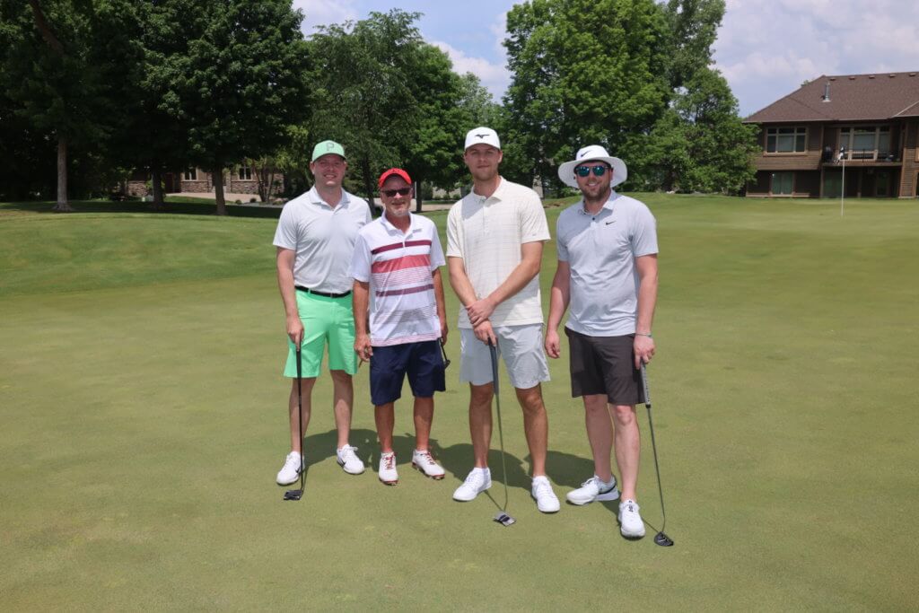 Four golfers pose for a photo on the Wilds Golf Club course at the 4th Annual Bridges to Learning Golf Tournament, Prior Lake Minnesota. Raising funds to educate and care for poor children in Vietnam.
