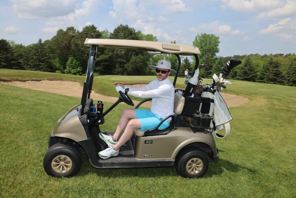 Golfer poses for a photo sitting in a cart at the Wilds Golf Club course at the 4th Annual Bridges to Learning Golf Tournament, Prior Lake Minnesota. Raising funds to educate and care for poor children in Vietnam.