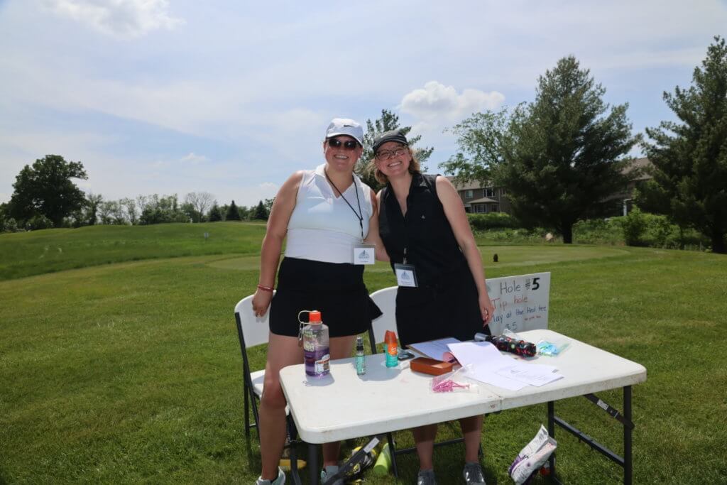 Two volunteers pose for a photo as they wait for the golfers to arrive to play games on the Wilds Golf Club course at the 4th Annual Bridges to Learning Golf Tournament, Prior Lake Minnesota. Raising funds to educate and care for impoverished children in Vietnam.