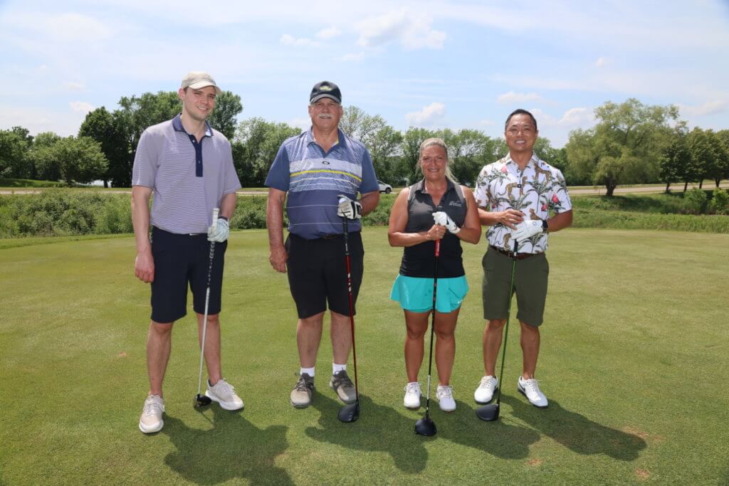 Four golfers pose for a photo on the Wilds Golf Club course at the 4th Annual Bridges to Learning Golf Tournament, Prior Lake Minnesota. Raising funds to educate and care for impoverished children in Vietnam.