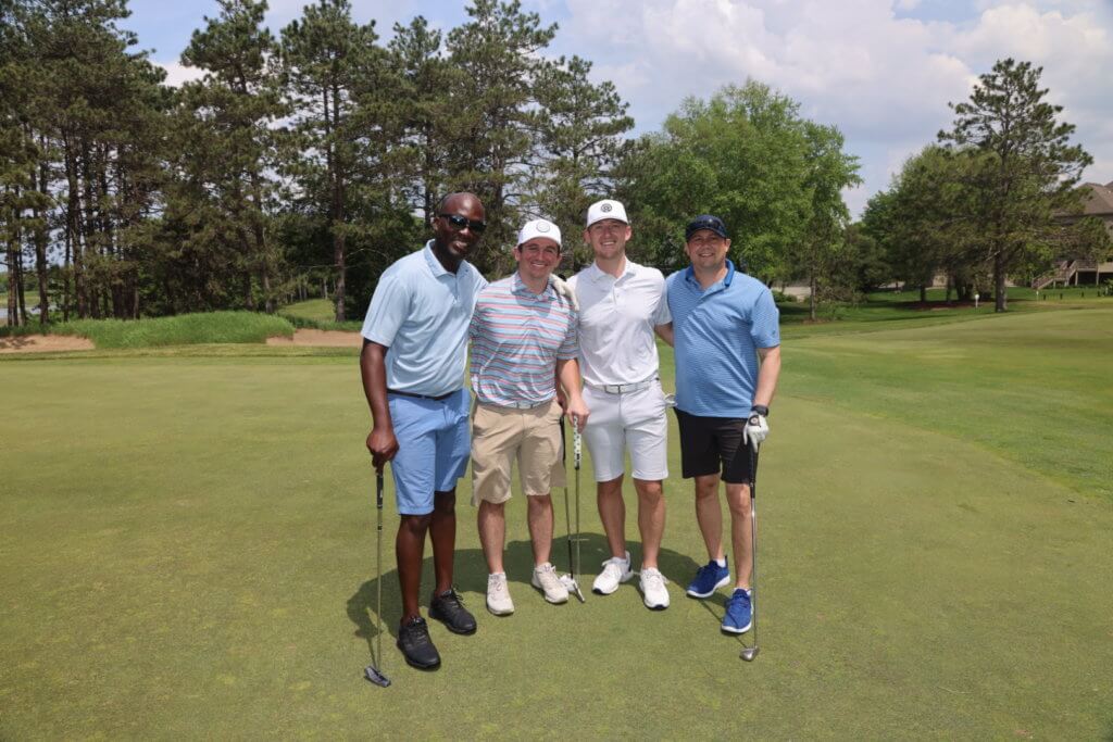 Four golfers pose for a photo on the Wilds Golf Club course at the 4th Annual Bridges to Learning Golf Tournament, Prior Lake Minnesota. Raising funds to educate and care for impoverished children in Vietnam.