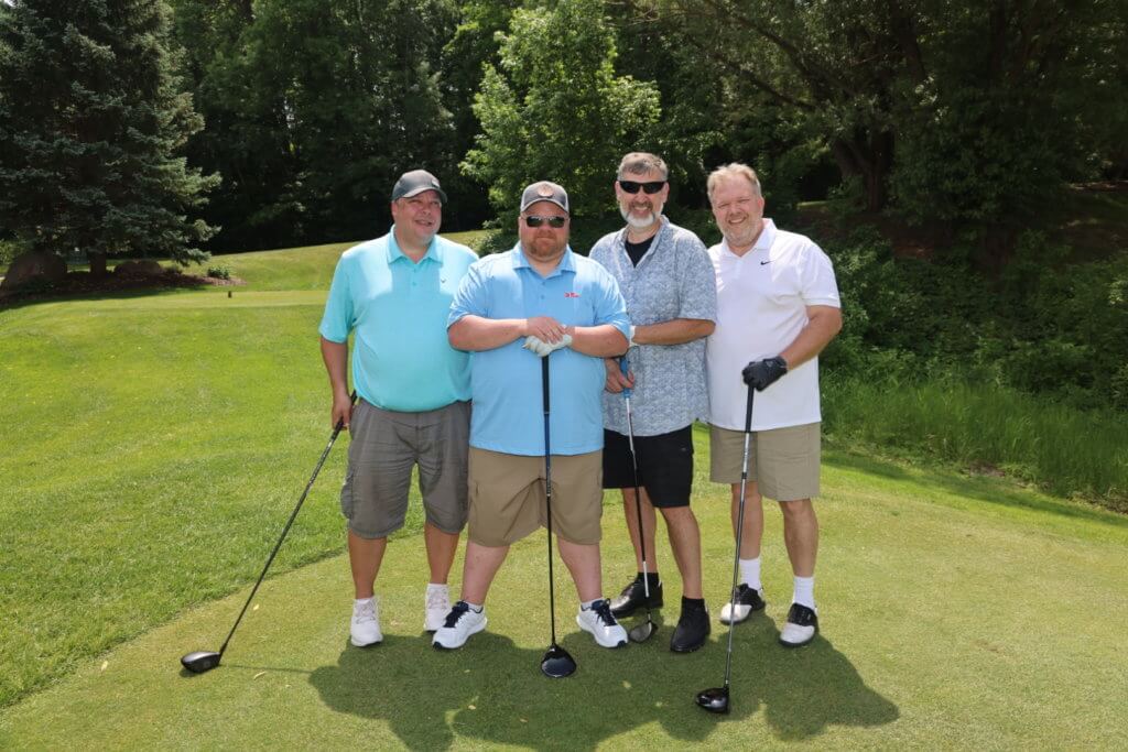 Four golfers pose for a photo on the Wilds Golf Club course at the 4th Annual Bridges to Learning Golf Tournament, Prior Lake Minnesota. Raising funds to educate and care for impoverished children in Vietnam.