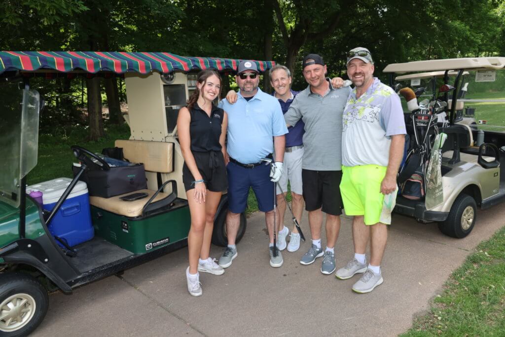 Four golfers take a break and pose for a photo with a snack cart employee on the Wilds Golf Club course at the 4th Annual Bridges to Learning Golf Tournament, Prior Lake Minnesota. Raising funds to educate and care for impoverished children in Vietnam.