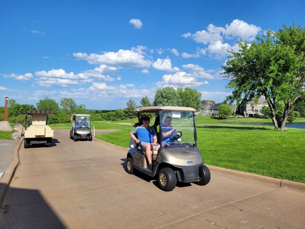 Bridges to Learning 3rd Annual Charity Tournament at The Wilds Golf Club, Prior Lake Minnesota. Happy golfers in golf carts driving out to play.