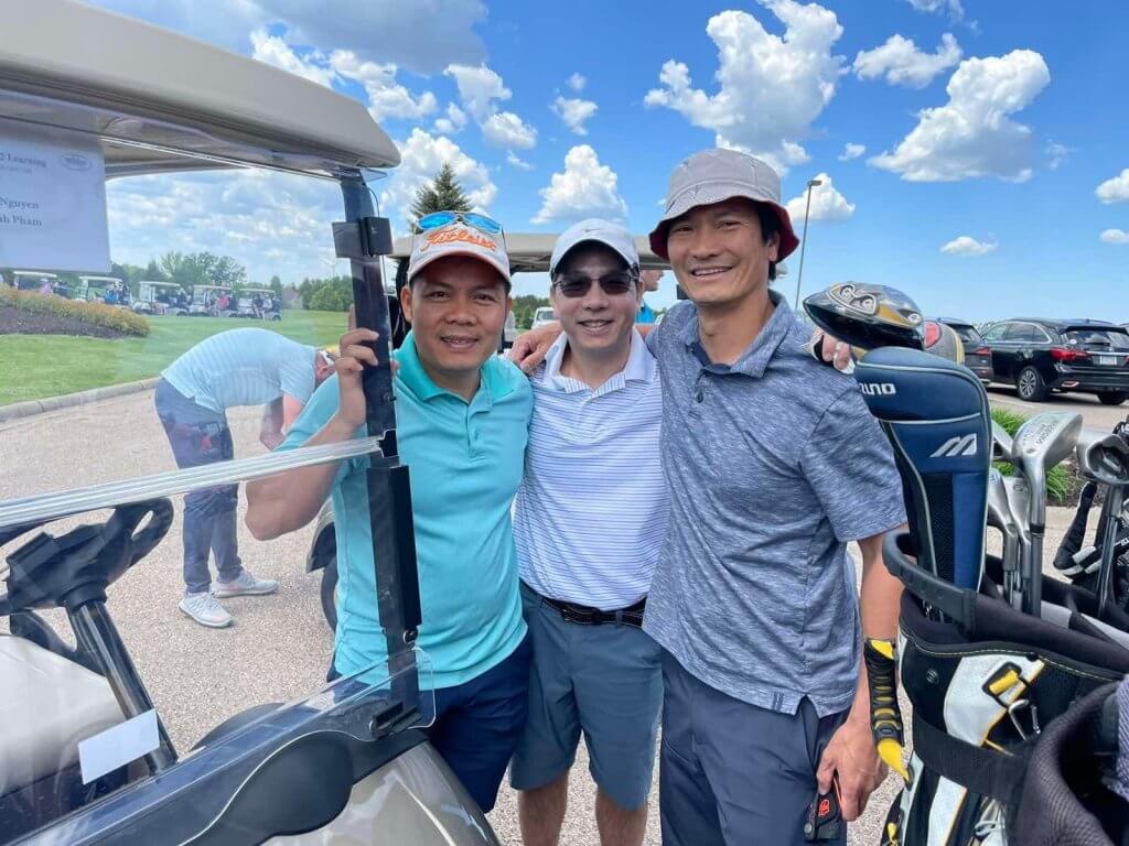 Bridges to Learning 3rd Annual Charity Tournament at The Wilds Golf Club, Prior Lake Minnesota. Happy golfers standing by their cart. Beautiful sunny sky.