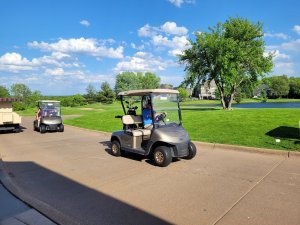 Golfers in golf carts headed out to the course to start the tournament. Bridges to Learning Golf.