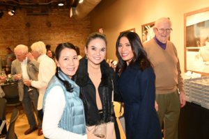 Bridges to Learning board member poses with smiling guests at 2022 Wine Tasting. Raising funds for impoverished children in Vietnam.