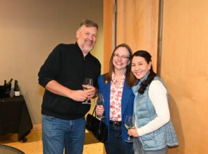 Bridges to Learning board member poses with smiling guests at 2022 Wine Tasting. Raising funds to educate poor children in Vietnam.