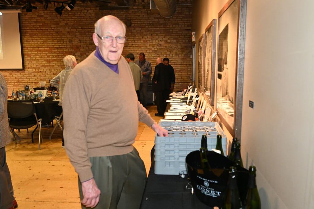 Bridges to Learning founder pouring bubbly for 2022 Wine Tasting guests.