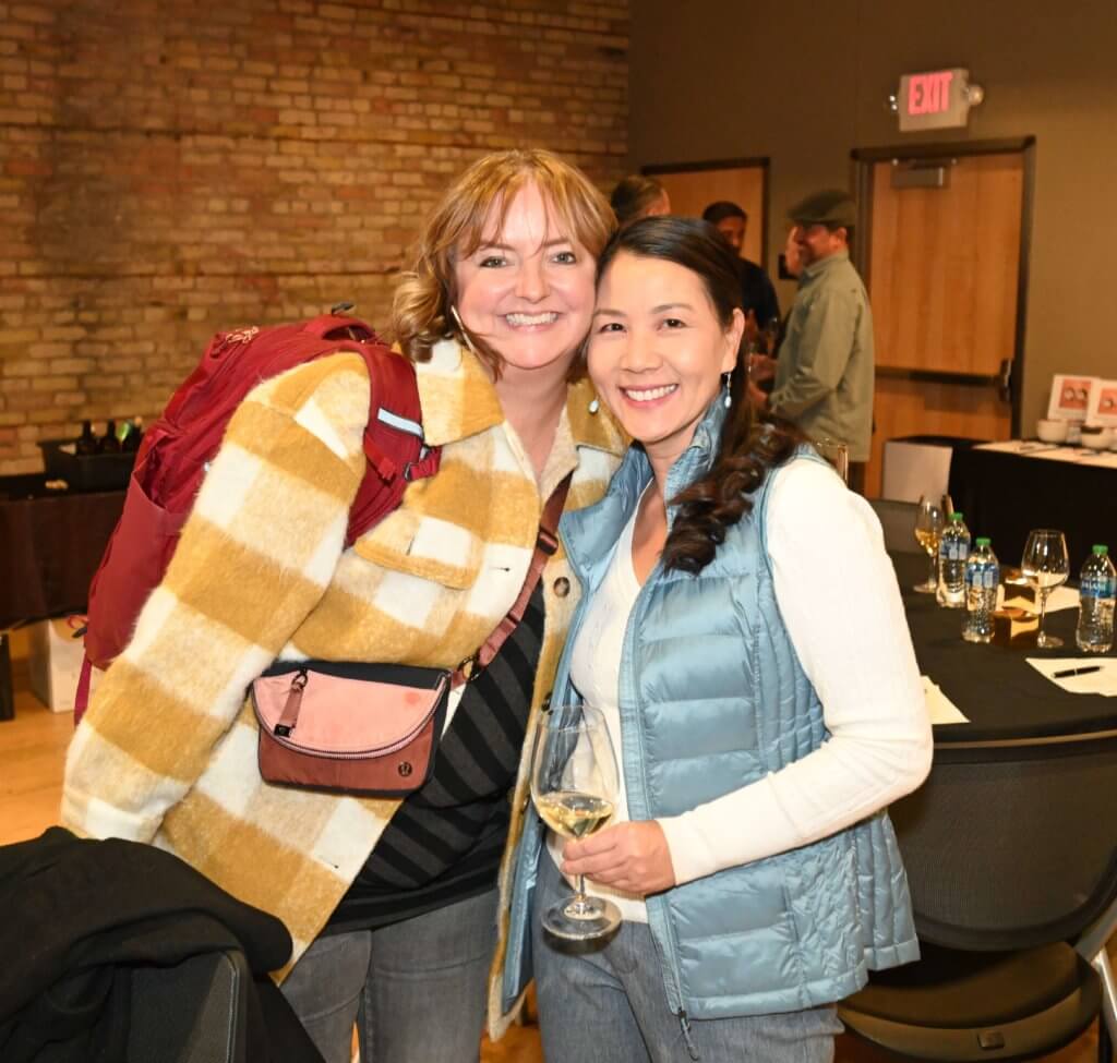 Bridges to Learning board member and friend smile and pose as they raise funds at 2022 Wine Tasting. Raise funds for poor children in Vienam.