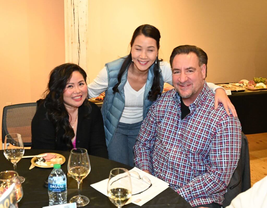 Bridges to Learning board member poses for a photo with two 2022 Wine Tasting guests. Nonprofit raising money to educate poor children in Vietnam.