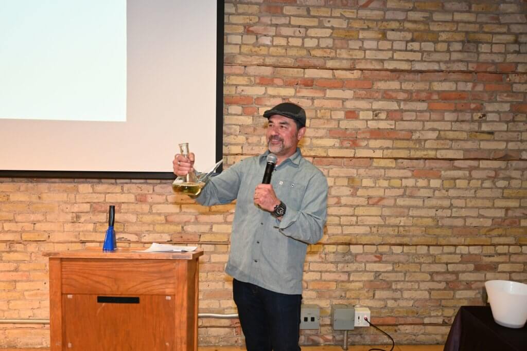 Joe Kotnik, owner Rootstock Wine Co. demonstrates his porron expertise at Bridges to Learning 2022 Wine Tasting. Nonprofit raising funds to educate poor children in Vietnam.