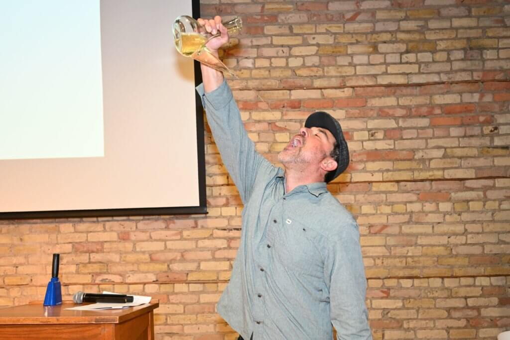 Joe Kotnik, owner Rootstock Wine Co. demonstrates his porron expertise at Bridges to Learning 2022 Wine Tasting. Nonprofit raising funds to educate poor children in Vietnam.