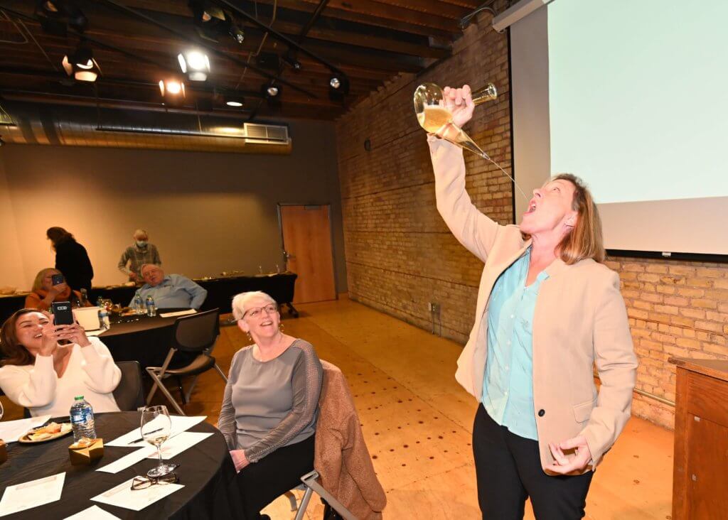 Bridges to Learning 2022 Wine Tasting guest demonstrates her skill with porron. Nonprofit raising funds to educate poor children in Vietnam.