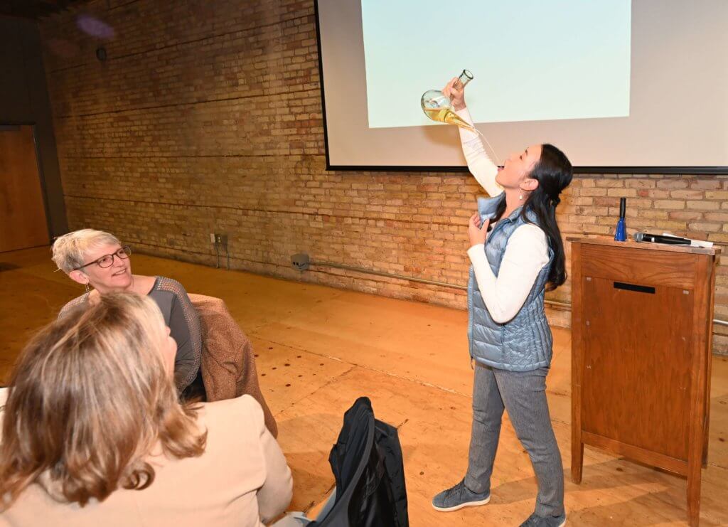 Bridges to Learning board member shows off her skill with a porron. Nonprofit 2022 Wine Tasting, raising money to educate poor children in Vietnam.