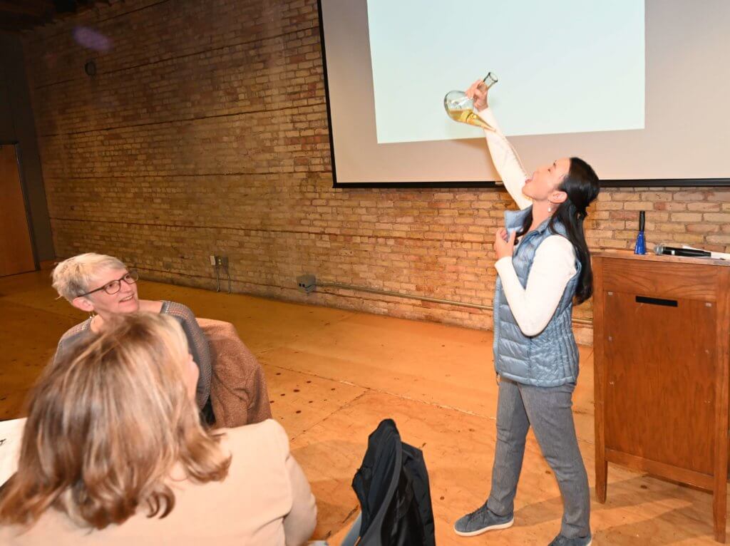 Bridges to Learning board member shows off her skill with a porron. Nonprofit 2022 Wine Tasting, raising money to educate poor children in Vietnam.