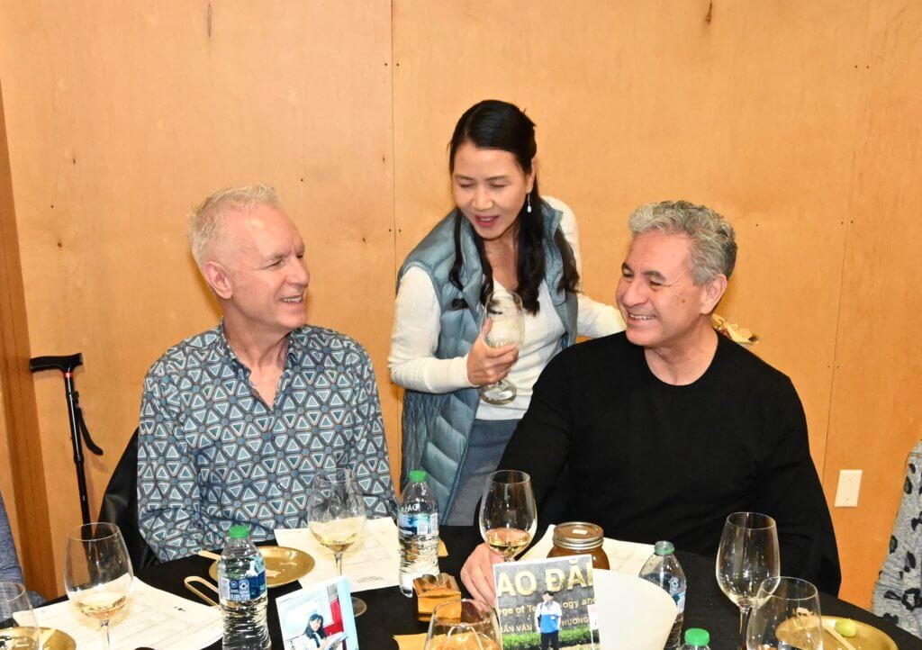 Bridges to Learning board member visits with two guests at the 2022 Wine Tasting. Nonprofit raising money to educate poor children in Vietnam.
