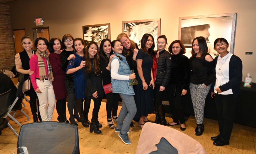 Bridges to Learning board member, former principal at the Anh Linh school, and many guests pose for a photo at the 2022 Wine Tasting fundraiser. Raising money to provide education to impoverished children in Vietnam. Open Book Minneapolis Minnesota.