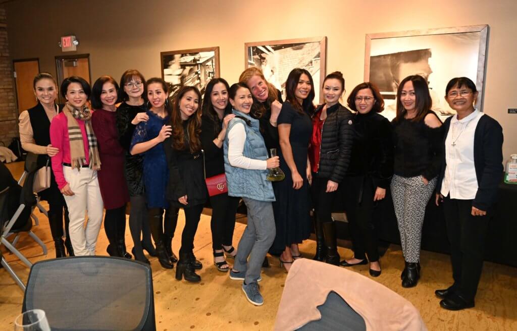 Bridges to Learning board member, former principal at the Anh Linh school, and many guests pose for a photo at the 2022 Wine Tasting fundraiser. Raising money to provide education to impoverished children in Vietnam. Open Book Minneapolis Minnesota.
