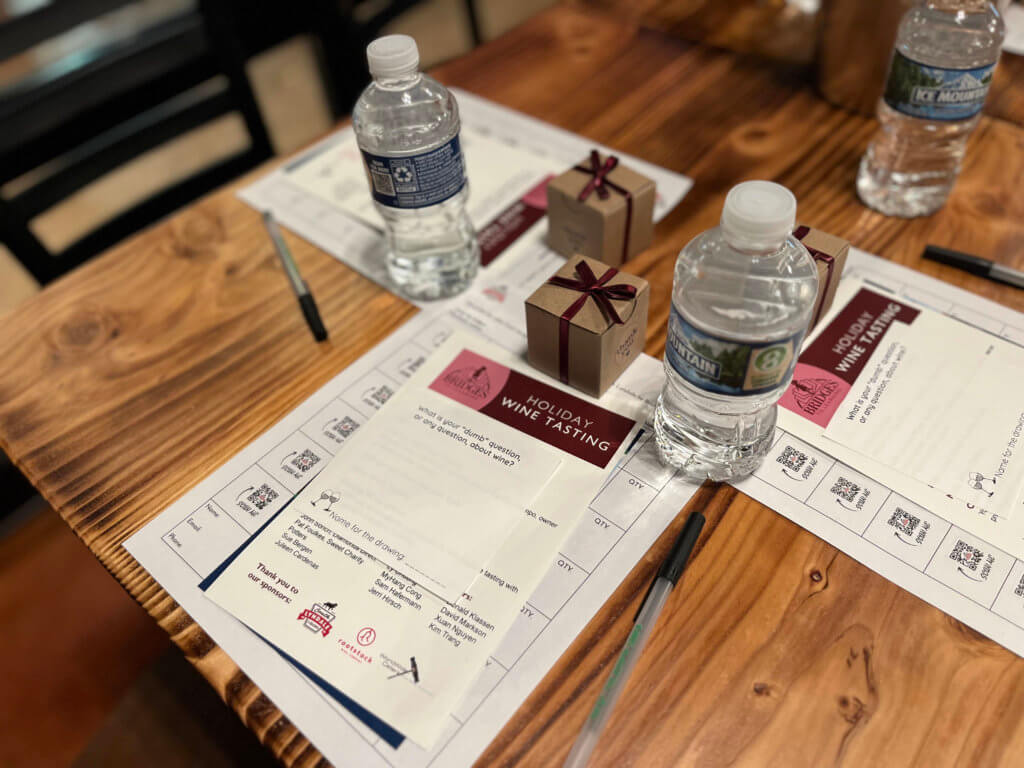 Place settings on tables for the 2023 Bridges to Learning Wine Tasting fundraiser. Nonprofit raising funds to educate and nourish poor children in Vietnam. South Lyndale Liquors event space.