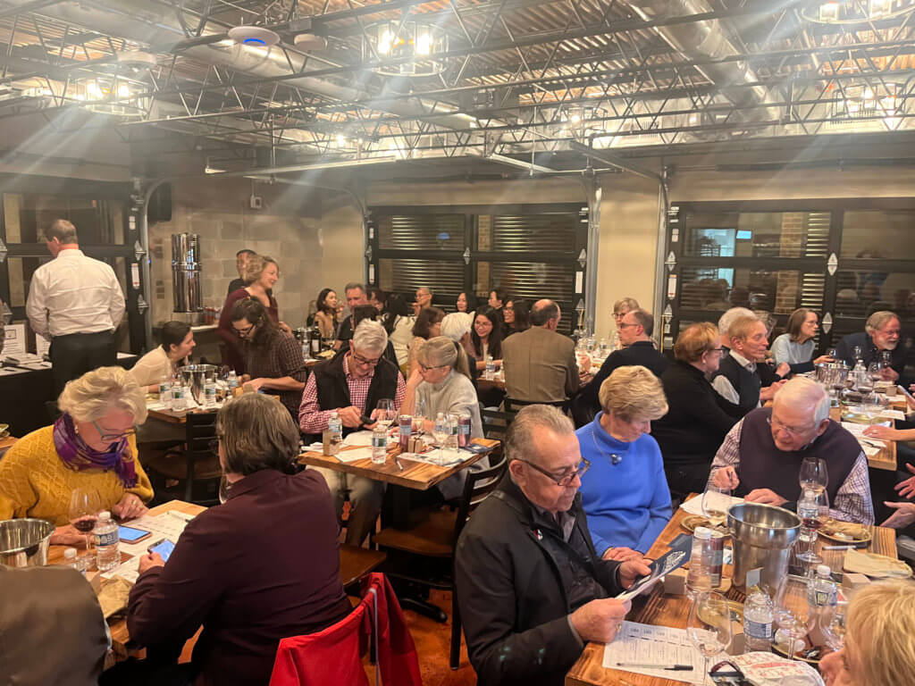 Guests at Bridges to Learning 2023 Wine Tasting sitting at tables. Supporting the education of impoverished children in Vietnam.