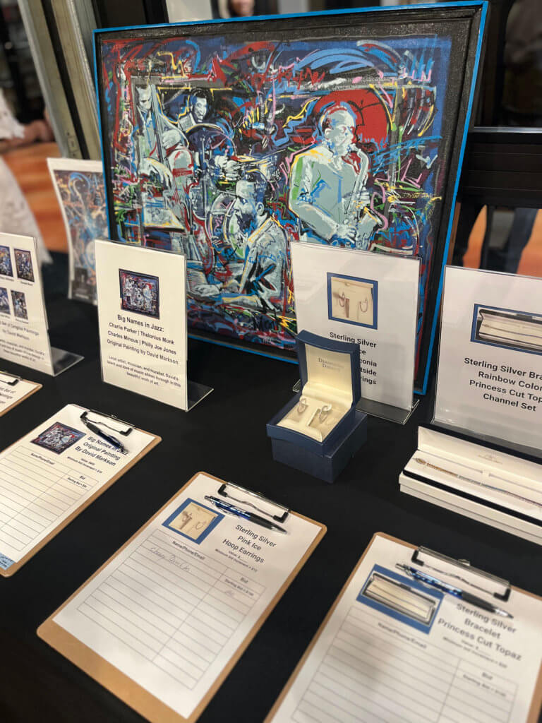 Table with jewelry donated by Diamonds Direct (Minnesota) for the silent auction at the 2023 Bridges to Learning Wine Tasting fundraiser. Nonprofit raising funds to educate and nourish poor children in Vietnam. South Lyndale Liquors event space.