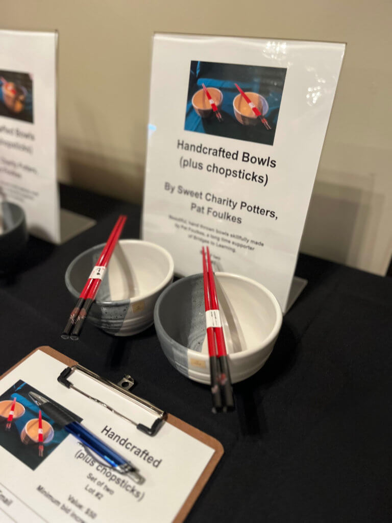 Table with beautiful Sweet Charity Pottery for the 2023 Bridges to Learning Wine Tasting fundraiser. Nonprofit raising funds to educate and nourish poor children in Vietnam. South Lyndale Liquors event space.