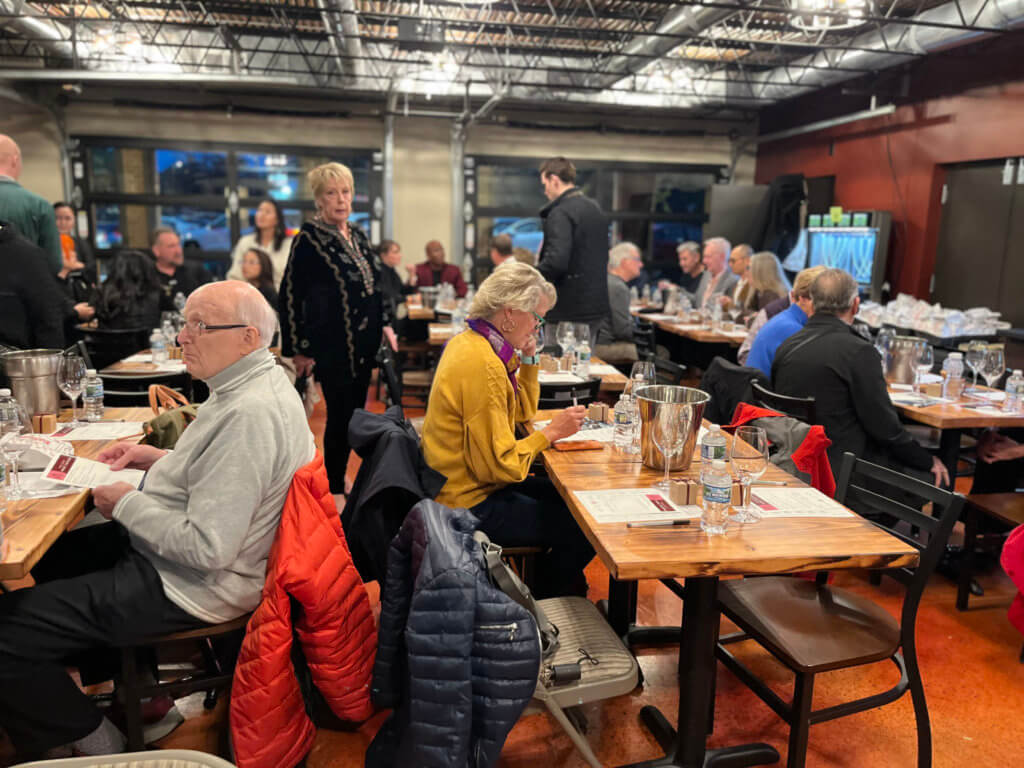 Guests at Bridges to Learning 2023 Wine Tasting sitting at tables. Supporting the education of impoverished children in Vietnam.