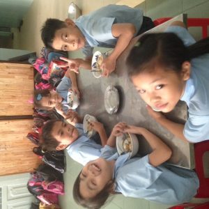 Children eating their lunch and smiling at Anh Linh School, Vietnam. Bridges to Lerning.