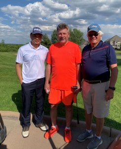 Three golfers pose for the camera on a beautiful day at the Wilds Golf Course in Prior Lake Minnesota. 2022 Bridges to Learning Golf Tournament.