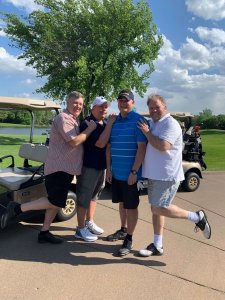 Four golfers mug for the camera on a beautiful day at the Wilds Golf Club in Minnesota. Raising funds for poor children in Vietnam at the Bridges to Learning Golf Tournament. 2022.