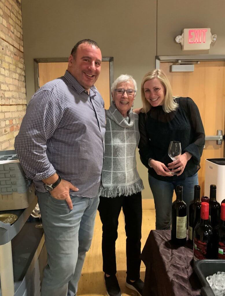 Bridges to Learning founder smiles with South Lyndale Liquor owners at the 2022 Wine Tasting charity fundraiser. Raising money to provide education to poor children in Vietnam.