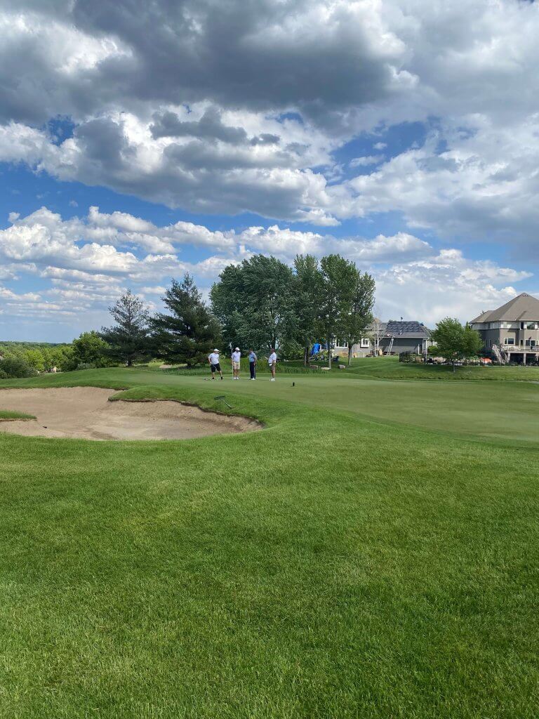 Bridges to Learning 3rd Annual Charity Tournament at The Wilds Golf Club, Prior Lake Minnesota. Beautiful landscape of the Wilds Golf Course with cloudy blue sky on a windy day. Golfers playing in the distance.  At tournament to raise funds for schools for impoverished children in Vietnam.