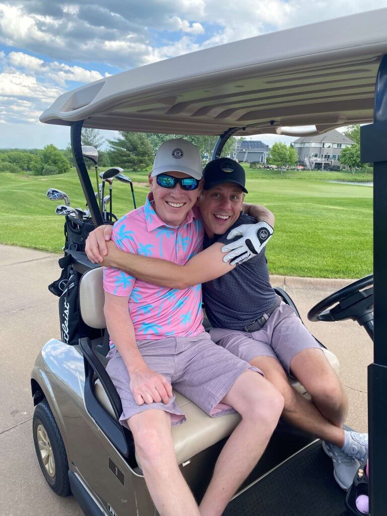 Bridges to Learning 3rd Annual Charity Tournament at The Wilds Golf Club, Prior Lake Minnesota. Happy friends sharing a hug and mugging for the camera in their golf cart ready to go to the hole and start the scramble, raising funds for schools for impoverished children in Vietnam.