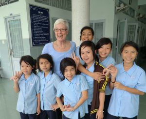 Bridges to Learning founder Jeri Fosdick Hirsch with students in uniform at Anh Linh School. Saigon HCMC Vietnam.