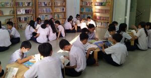 Kids in new library, sitting on floor at tables. Anh Linh School Saigon HCMC Vietnam.