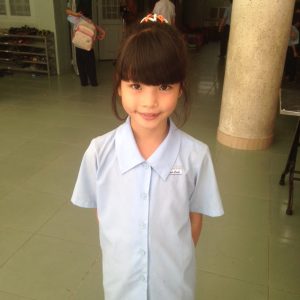 Young girl in Anh Linh School uniform smiling and posing for the camera.