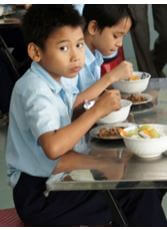 Child eating healthy meal at Anh Linh School, Vietnam.